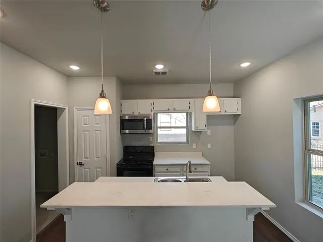 a kitchen with kitchen island a sink stainless steel appliances and window