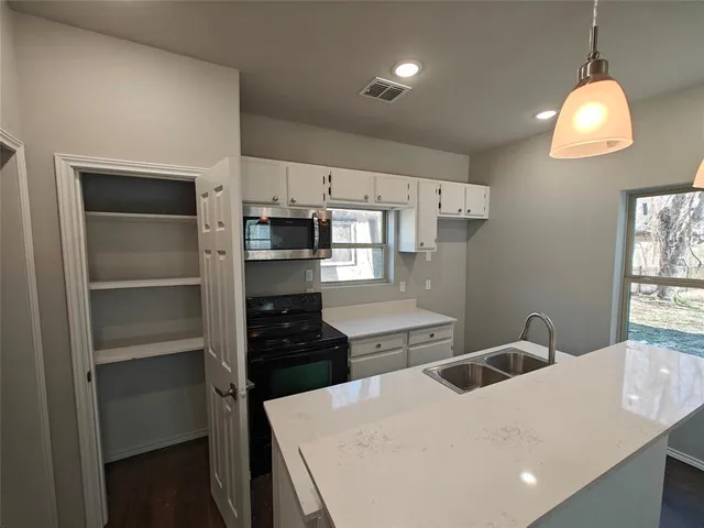 a kitchen with a refrigerator and a stove top oven