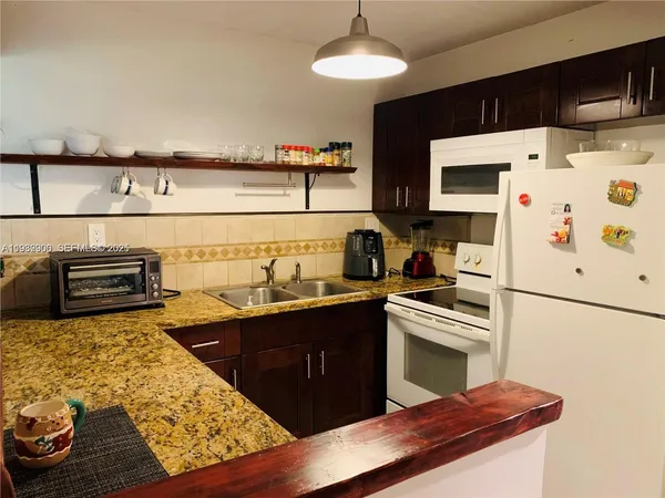 a kitchen with stainless steel appliances a stove a sink and a refrigerator