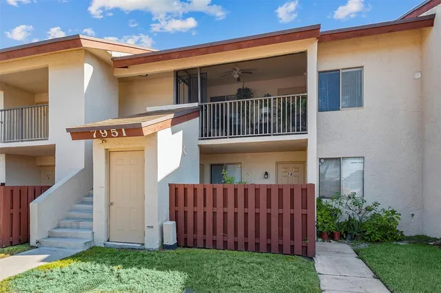 a view of a house with a small yard and wooden floor and fence