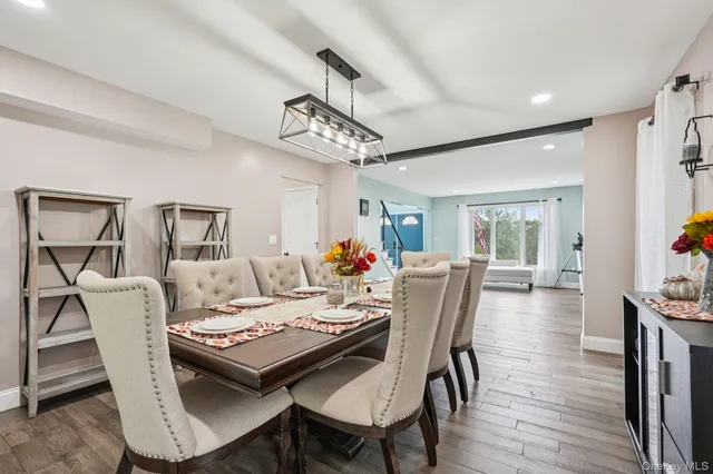 a large white kitchen with a stove a sink dishwasher and a refrigerator with wooden floor