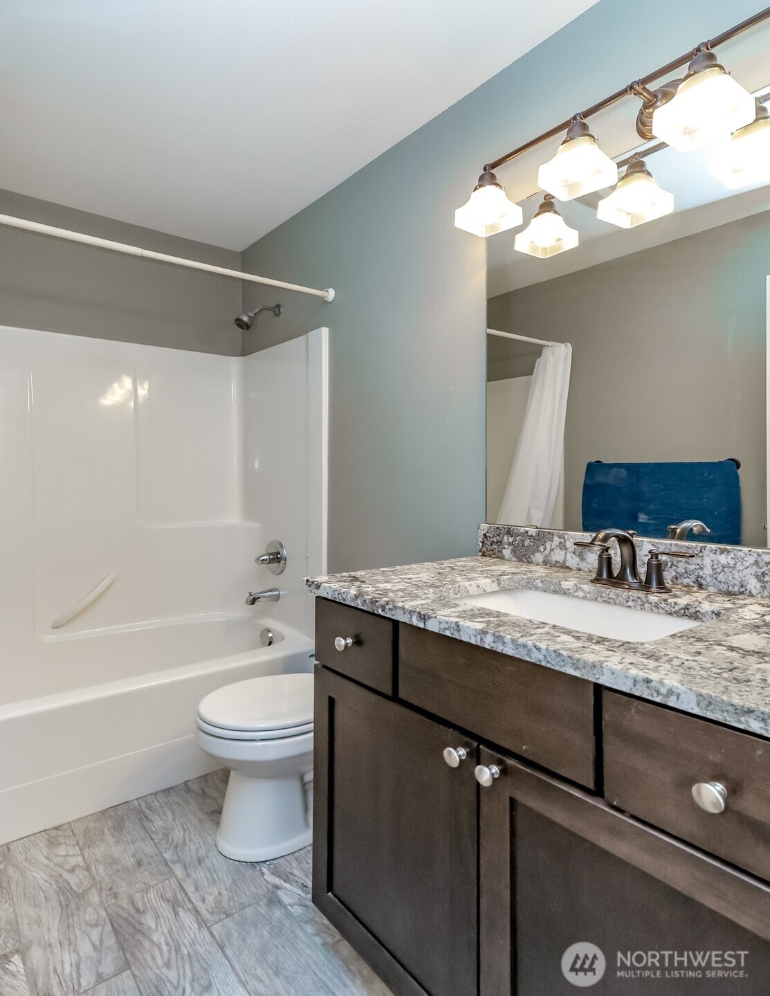 6820 9th Street East Fife, WA 98424 - Photo 23 of 40 a bathroom with a granite countertop sink toilet a large mirror a bathtub and shower