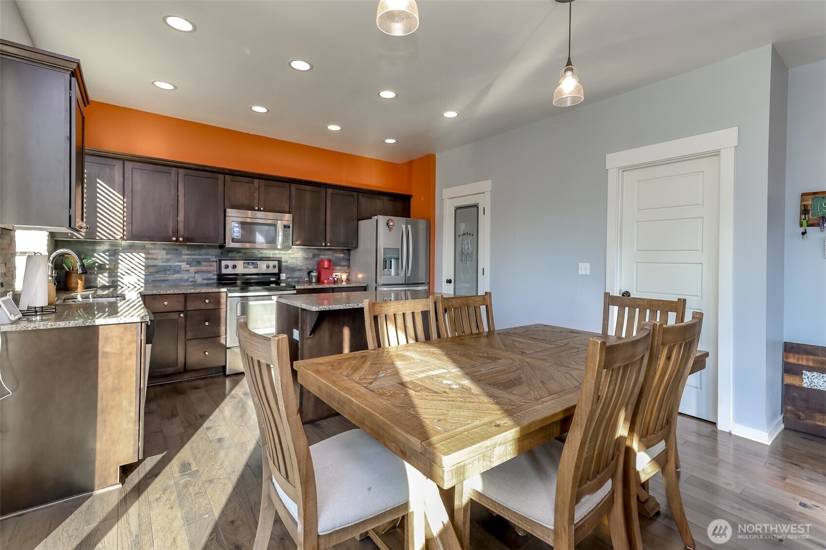 6820 9th Street East Fife, WA 98424 - Photo 8 of 40 a kitchen with kitchen island granite countertop a dining table chairs stainless steel appliances and cabinets