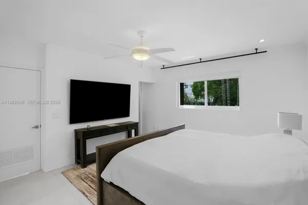a bedroom with a bed and a flat screen tv