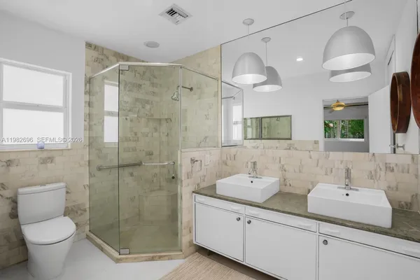 a bathroom with a double vanity sink toilet and shower