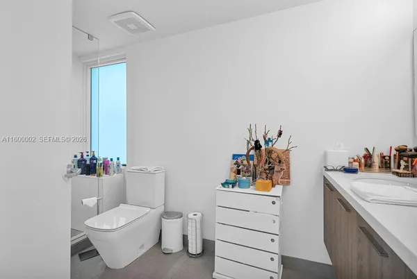 a bathroom with a sink mirror vanity and toilet