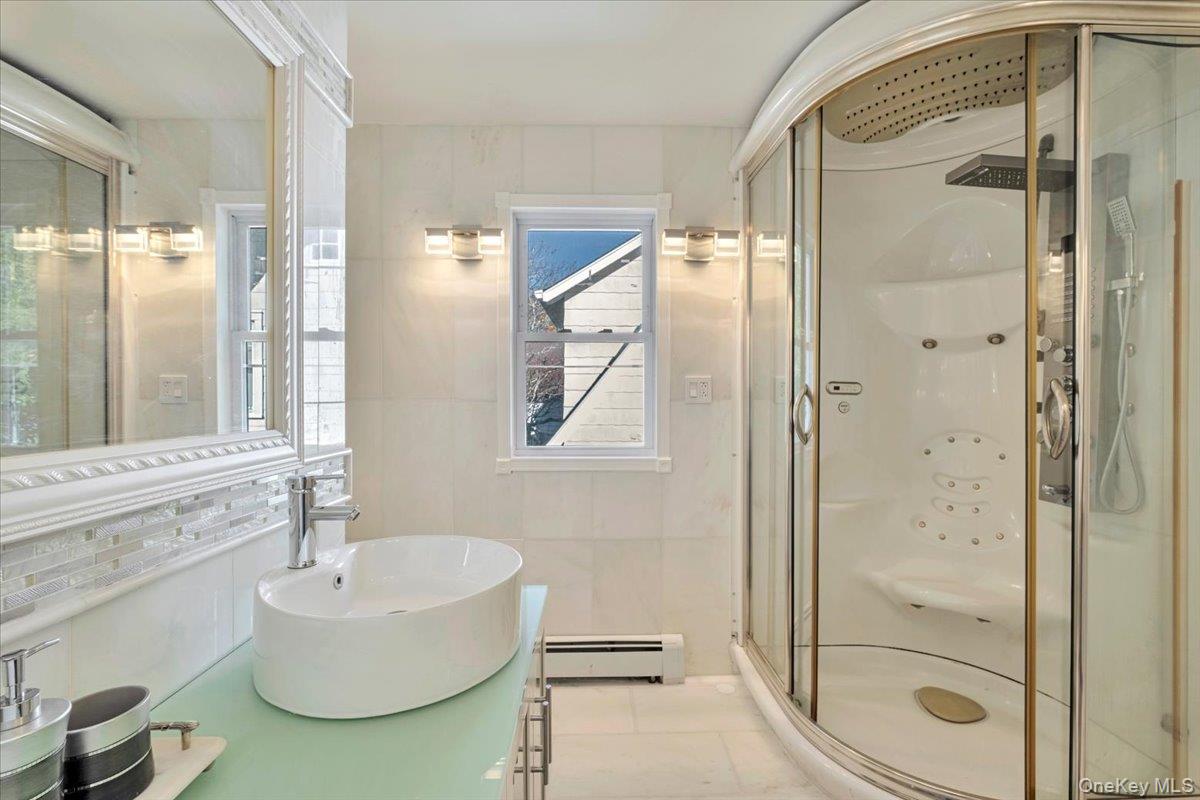193 Nelson Road Scarsdale, NY 10583 - Photo 30 of 37 a bathroom with a tub and a shower