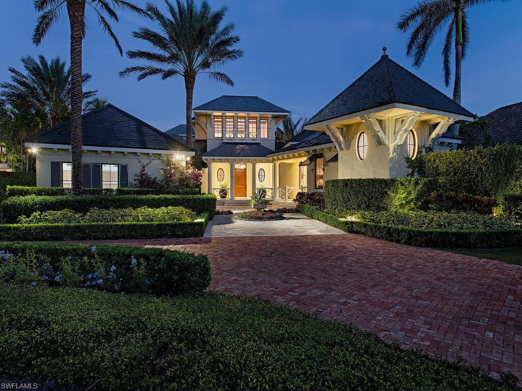 3787 Fort Charles Drive Naples, FL 34102 - Photo 1 of 48 a front view of a house with a yard