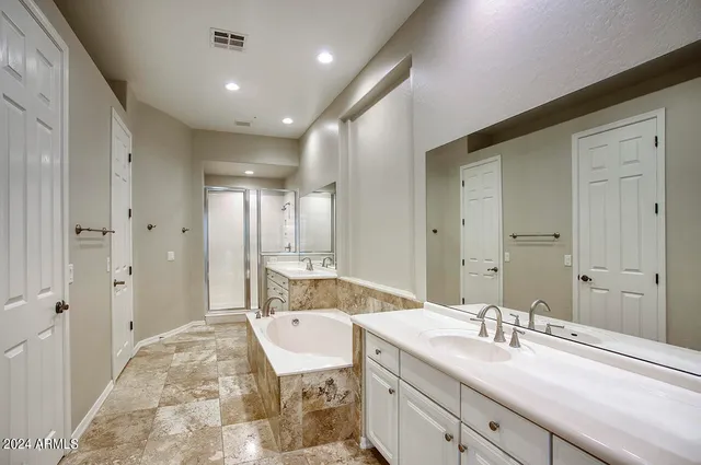 a spacious bathroom with a granite countertop sink mirror and a bath tub