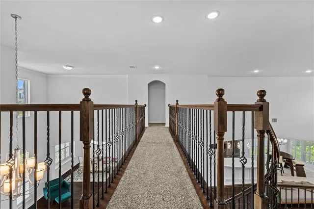 a view of a hallway with wooden floor and stairs