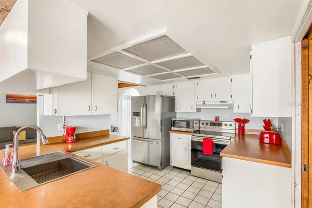 a kitchen with stainless steel appliances granite countertop a sink and a refrigerator