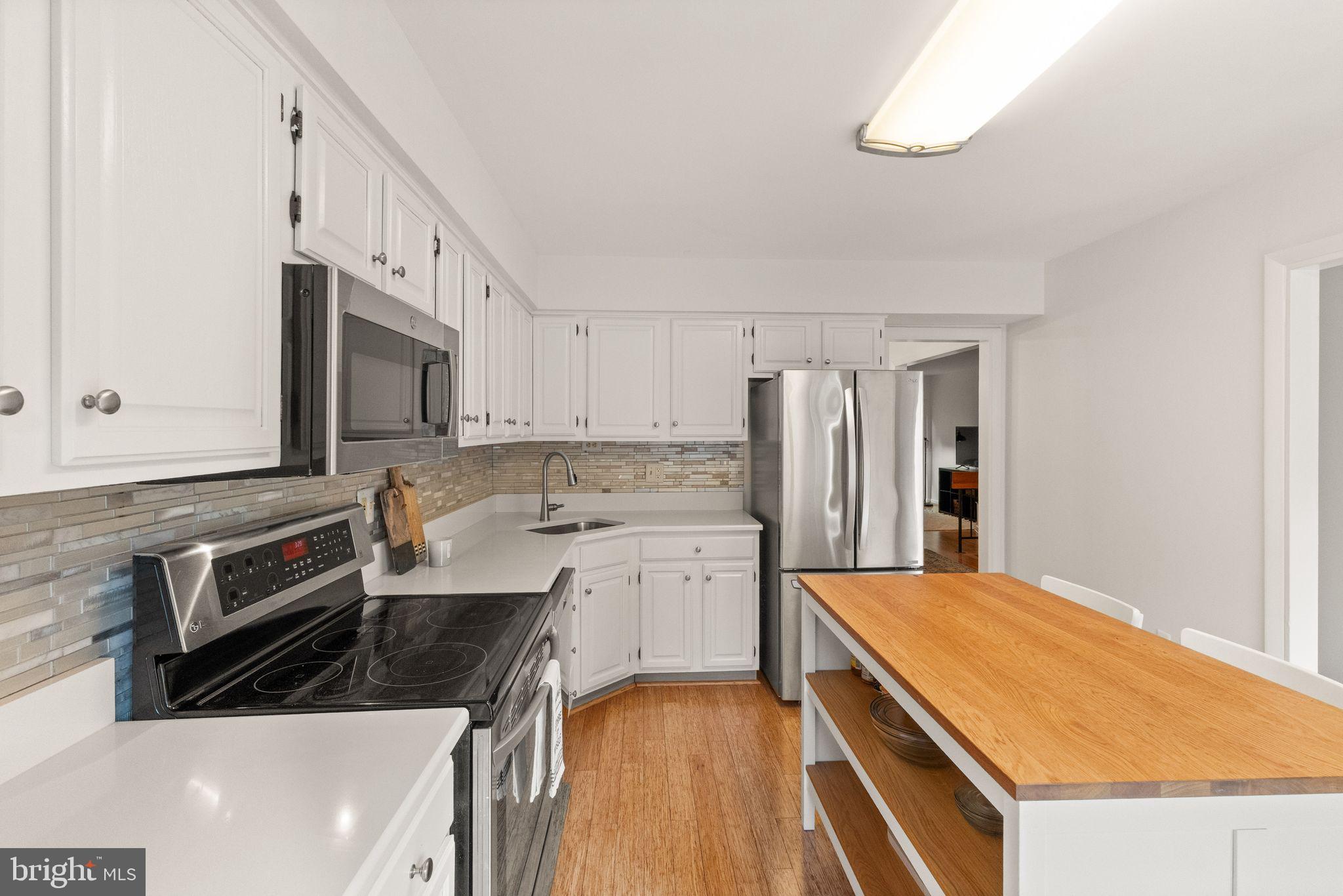 11645 Newbridge Court Reston, VA 20191 - Photo 11 of 62 a kitchen with a sink a stove a microwave and cabinets
