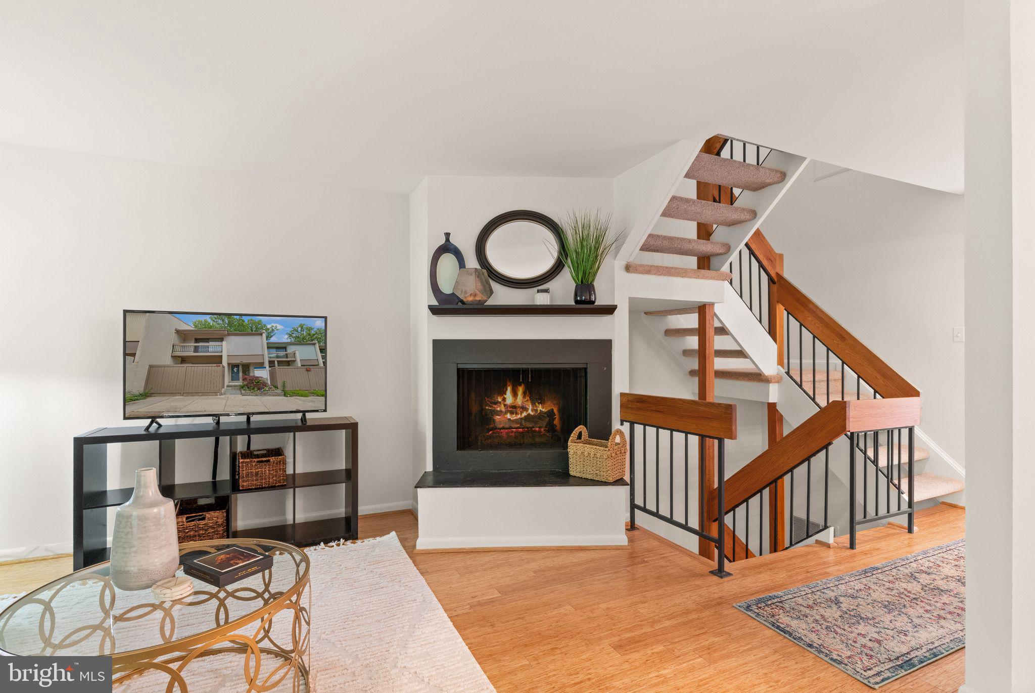 11645 Newbridge Court Reston, VA 20191 - Photo 23 of 62 a living room with furniture a fireplace and a wooden floor