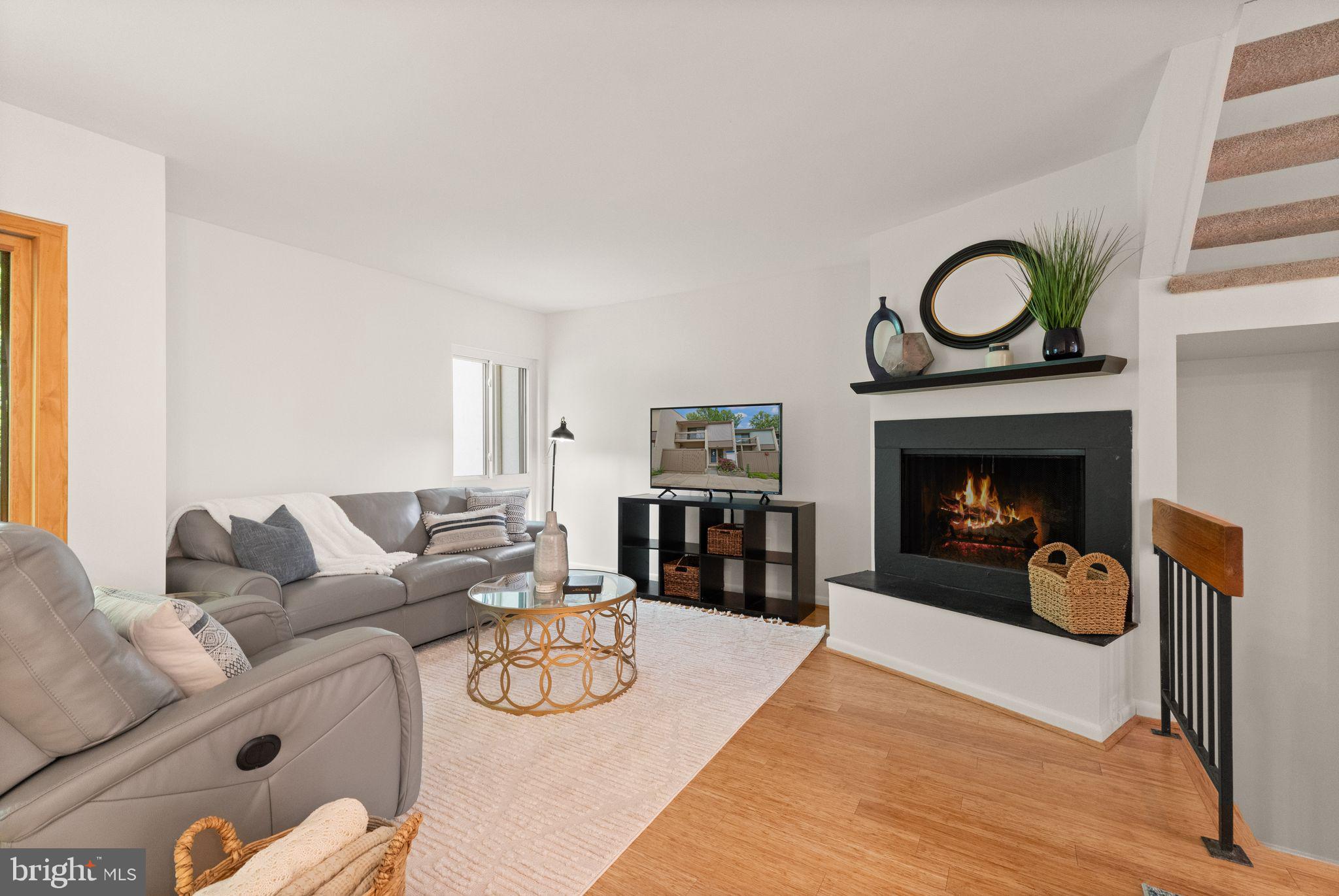 11645 Newbridge Court Reston, VA 20191 - Photo 24 of 62 a living room with furniture a fireplace a rug and a window