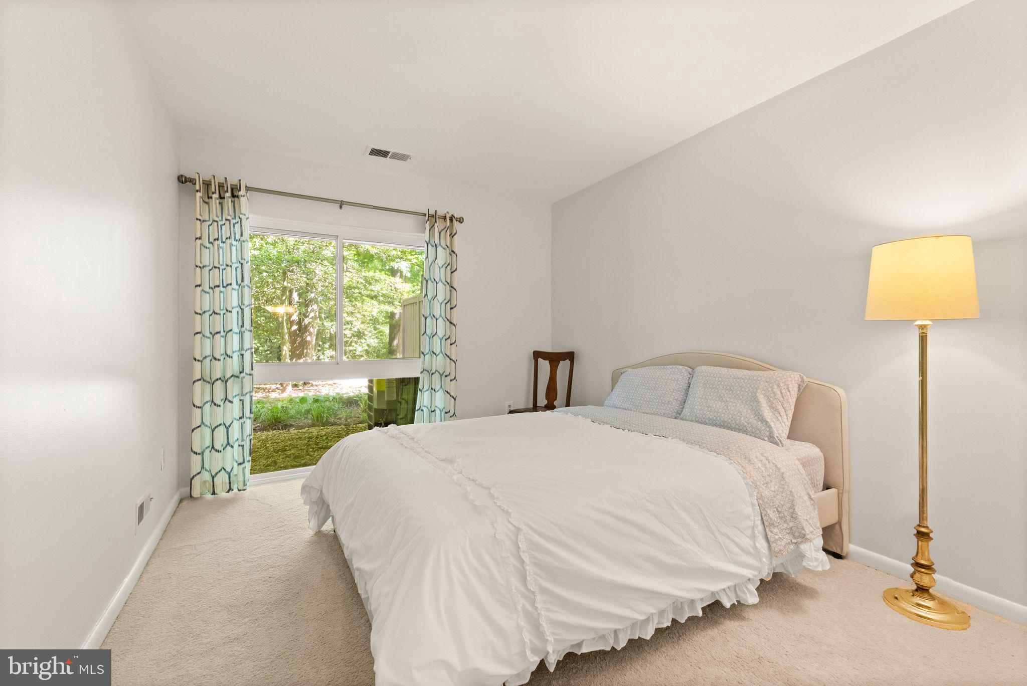 11645 Newbridge Court Reston, VA 20191 - Photo 45 of 62 a bedroom with a bed and a lamp