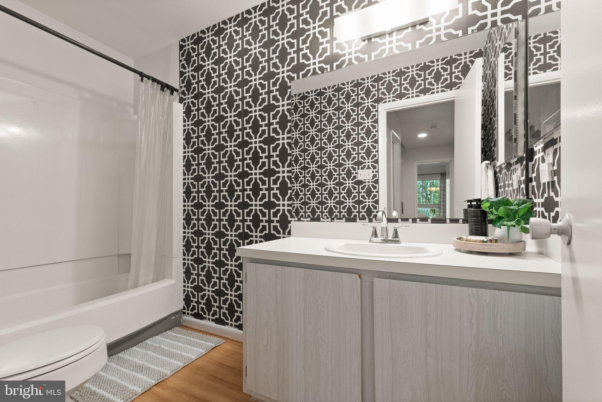 11645 Newbridge Court Reston, VA 20191 - Photo 58 of 62 a bathroom with a sink a mirror and a bathtub