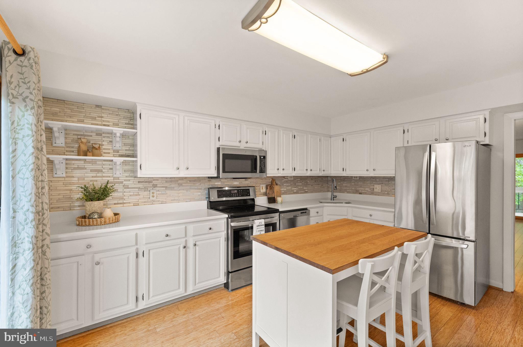 11645 Newbridge Court Reston, VA 20191 - Photo 8 of 62 a kitchen with white cabinets and stainless steel appliances