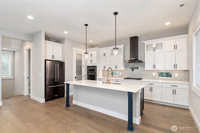 a kitchen with stainless steel appliances kitchen island a refrigerator sink and cabinets