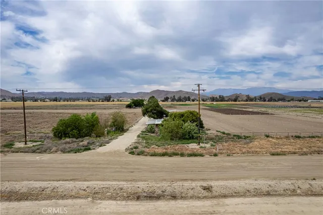 a view of a house with a yard and large trees