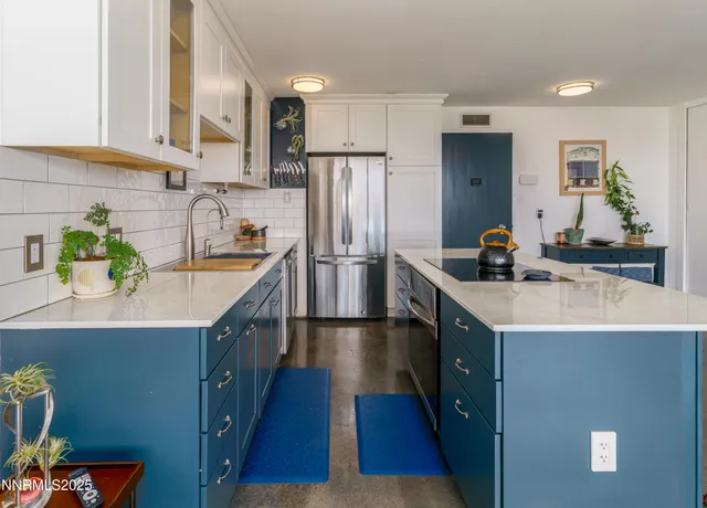 a kitchen with stainless steel appliances a sink stove refrigerator and cabinets