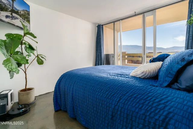 a bedroom with a bed table flowerpot and window