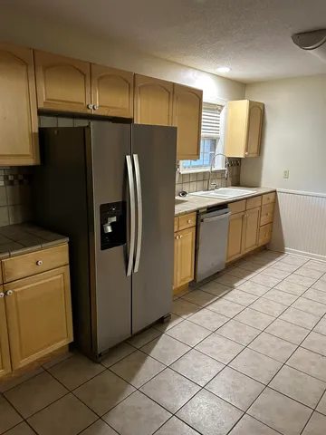 a kitchen with stainless steel appliances a refrigerator sink and microwave