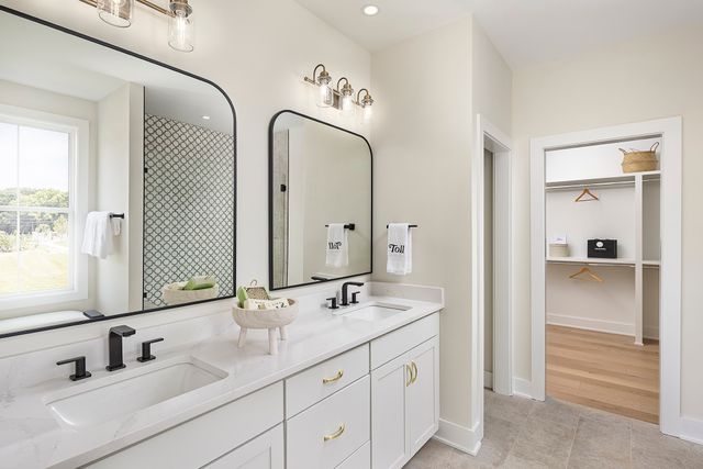 a bathroom with double vanity sinks and a mirror