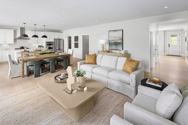 a living room with furniture kitchen view and a table