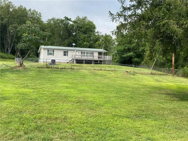 a front view of a house with a yard table and seating