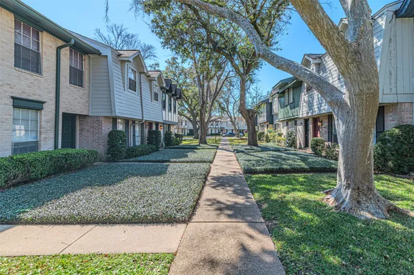 a front view of a house with a yard and trees