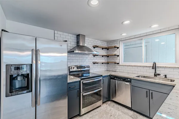 a large kitchen with granite countertop a sink and a stove