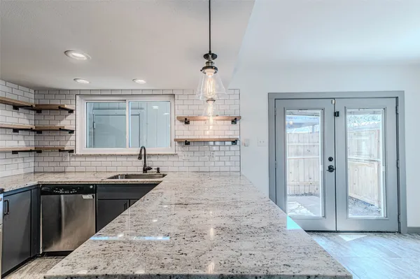 a view of a livingroom with wooden floor a ceiling fan and windows