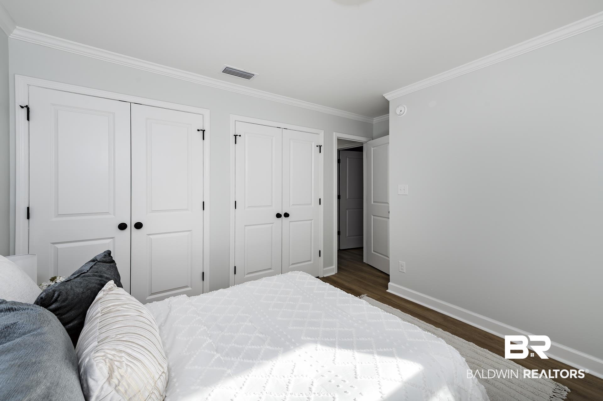 6001 Camp Halls Mill Road Mobile, AL 36619 - Photo 42 of 52 Bedroom featuring multiple closets, crown molding, and dark wood-type flooring