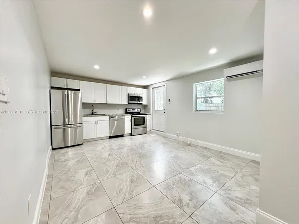 a view of kitchen with wooden cabinets and refrigerator