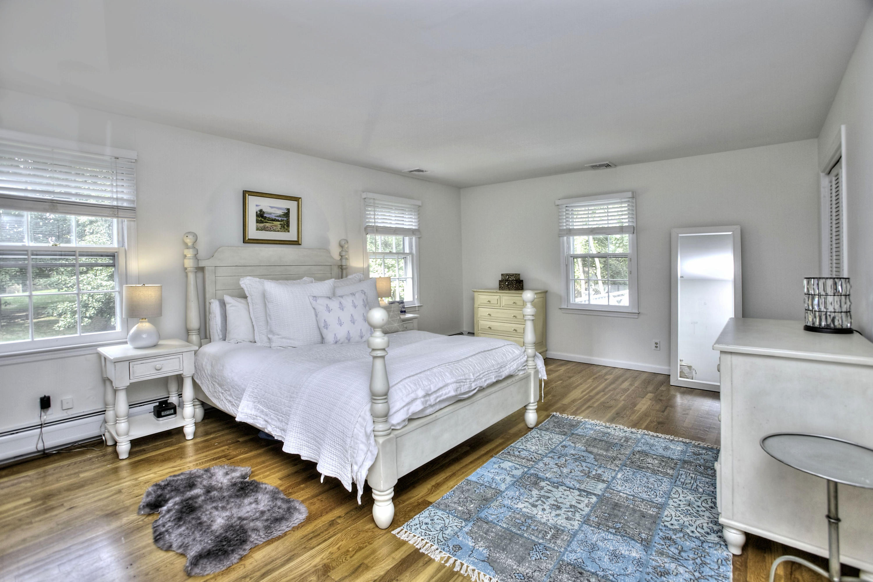 176 White Oak Shade Road New Canaan, CT 06840 - Photo 16 of 33 a bedroom with a bed and a table in it with wooden floor