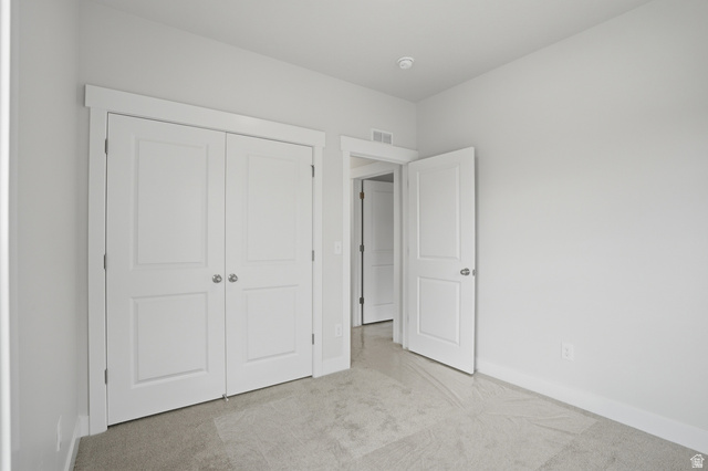 7338 South Seven Tree Lane, Unit 75 Midvale, UT 84047 - Photo 22 of 30 Unfurnished bedroom featuring light colored carpet and a closet
