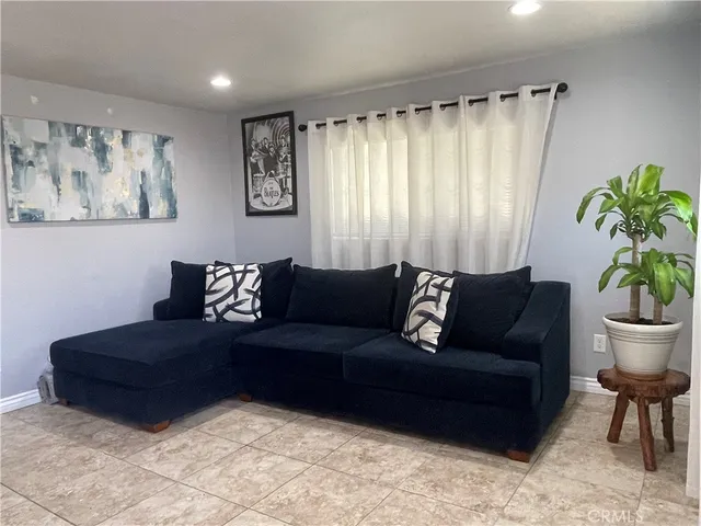 a living room with furniture and a potted plant