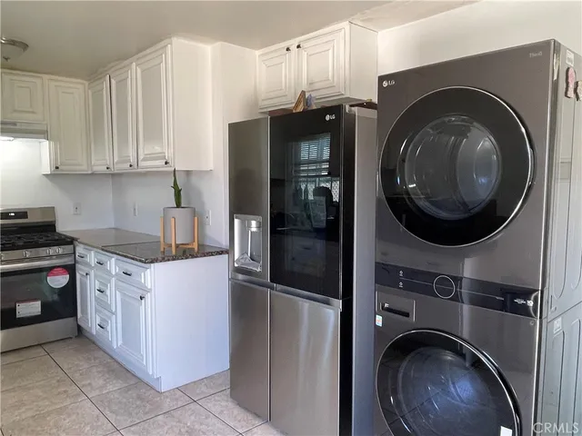 a kitchen with stainless steel appliances granite countertop a refrigerator and a stove top oven