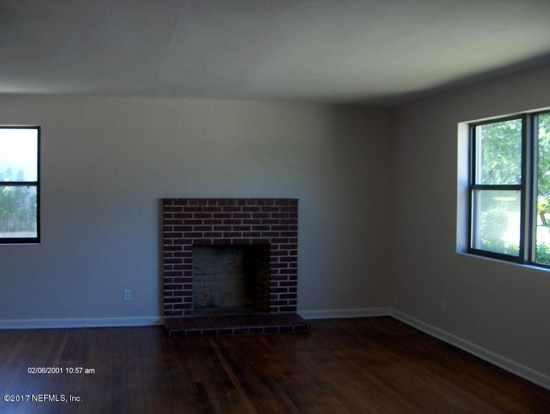 3722 Coronado Road Jacksonville, FL 32217 - Photo 8 of 20 a view of an empty room with wooden floor fireplace and a window