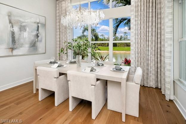 2695 Ridgecrest Place Naples, FL 34112 - Photo 8 of 13 Dining area with wood finished floors, a chandelier, and a water view