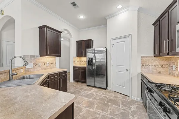 a kitchen with stainless steel appliances granite countertop a sink stove and refrigerator