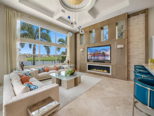 a living room with furniture a floor to ceiling window and a flat screen tv