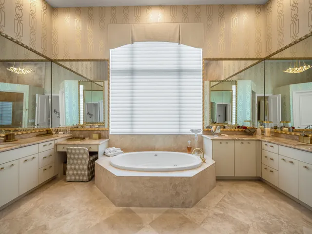 a bathroom with a granite countertop tub sink and mirror