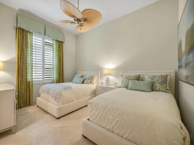 a spacious bedroom with two bed and a large window