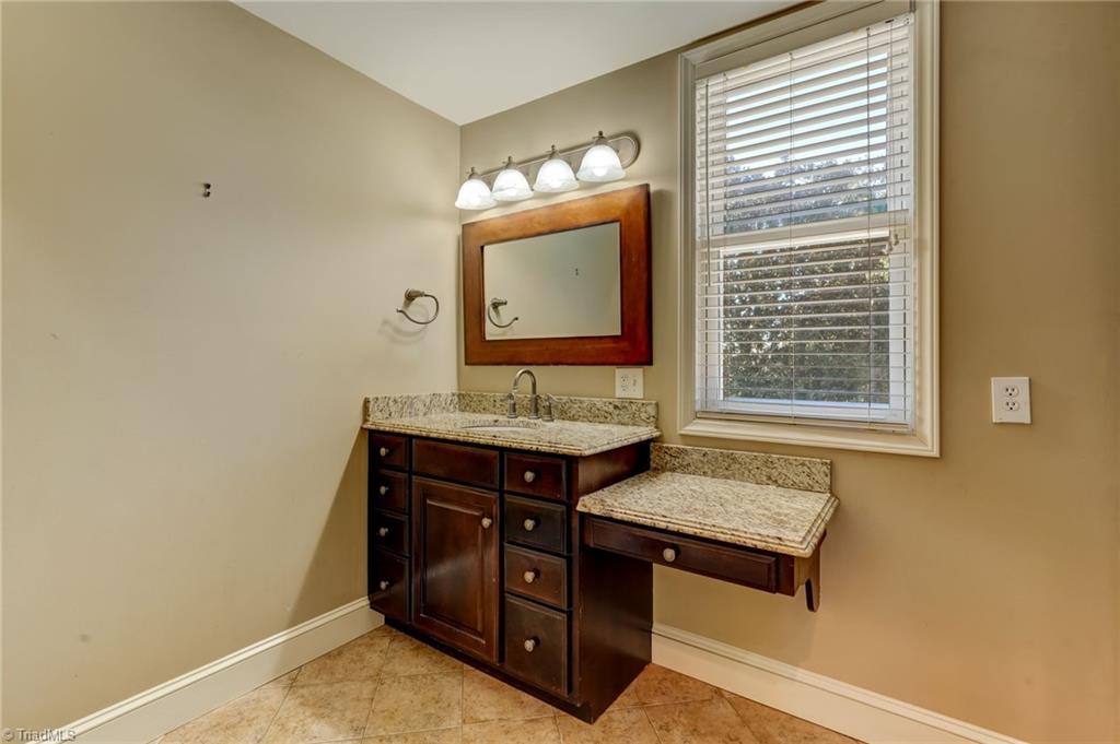 521 Patrick Street Eden, NC 27288 - Photo 40 of 50 Primary en suite bathroom with dressing table and granite countertops