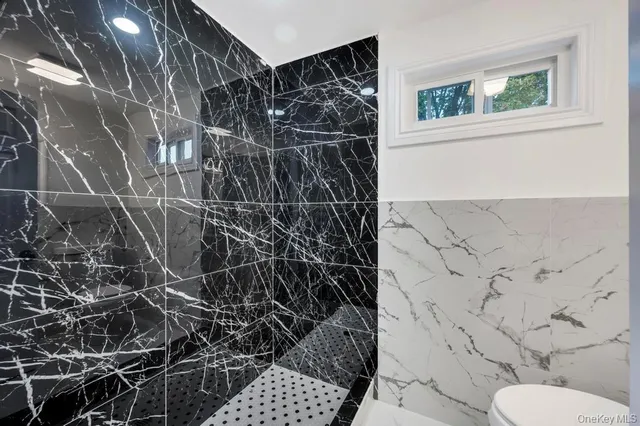 a bathroom with a toilet and a shower