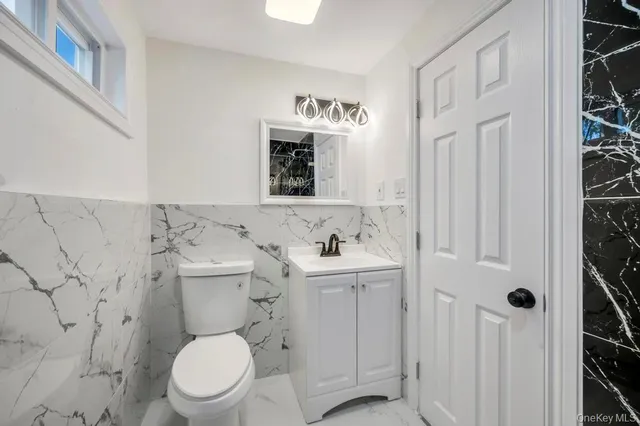 a bathroom with a toilet sink and mirror