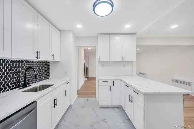 a kitchen with white cabinets appliances and sink