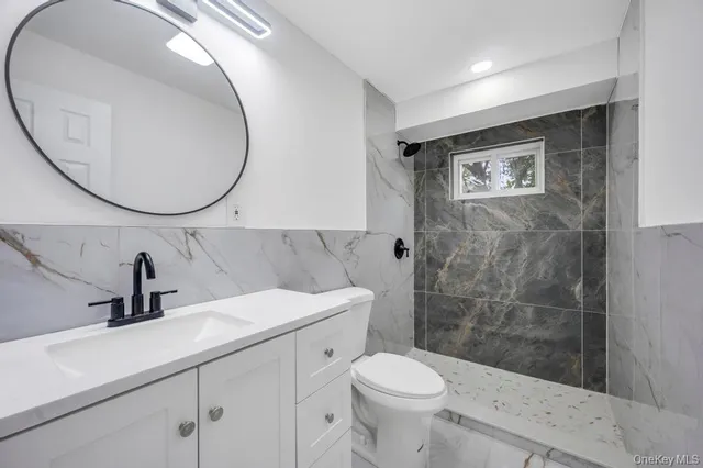 a bathroom with a sink a toilet and a mirror