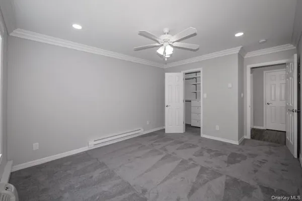 an empty room with closet and a chandelier fan
